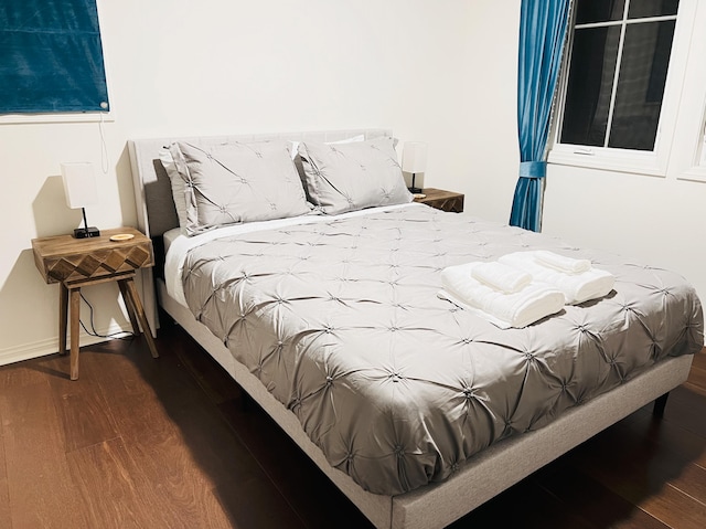 bedroom with baseboards and wood finished floors