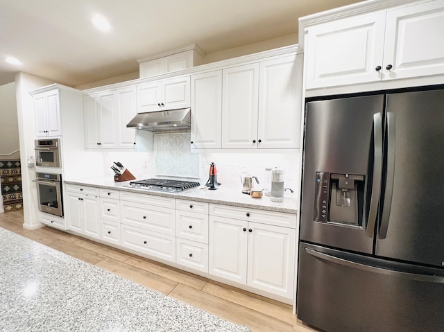 kitchen featuring decorative backsplash, under cabinet range hood, white cabinets, and appliances with stainless steel finishes