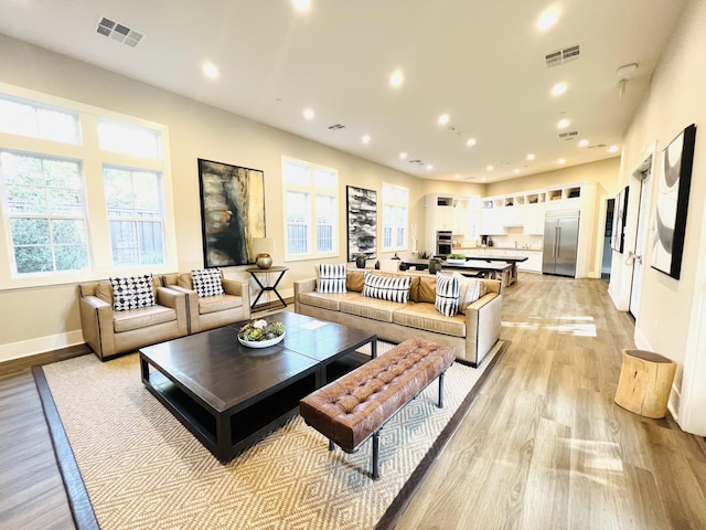 living room with recessed lighting, a healthy amount of sunlight, and visible vents