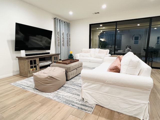 living room with recessed lighting, wood finished floors, visible vents, and baseboards