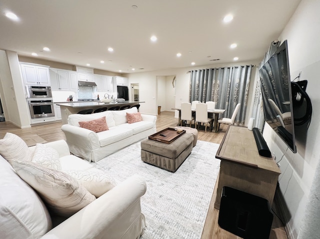 living area featuring recessed lighting and light wood finished floors