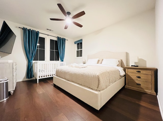 bedroom with visible vents, a ceiling fan, and dark wood-style flooring