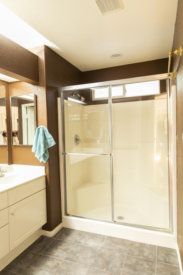 full bathroom featuring a stall shower, vanity, visible vents, and tile patterned floors