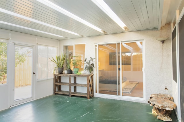 doorway to outside with a textured wall and finished concrete flooring