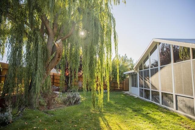 view of yard featuring a fenced backyard and a sunroom