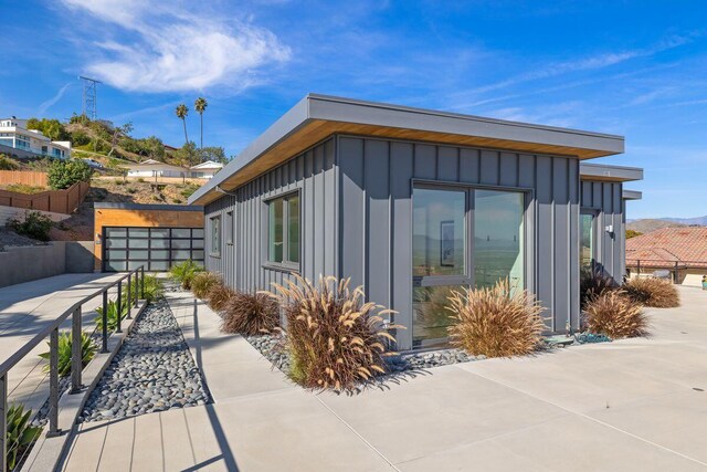 153 Nob Hill Ln, Ventura, CA 93003 - view of side of property featuring board and batten siding, driveway, fence, and a garage