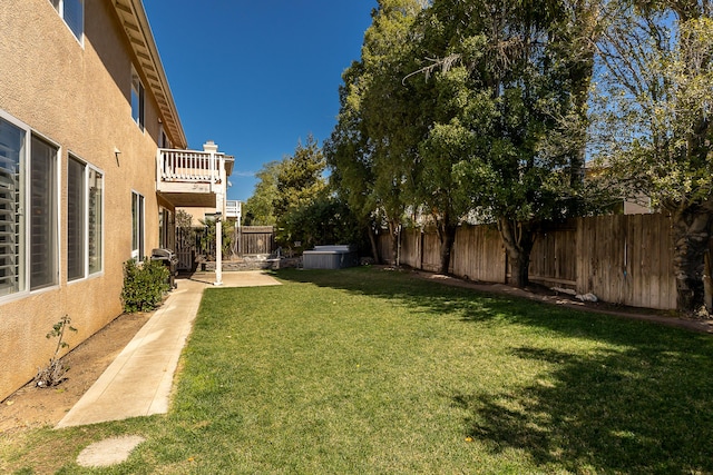 view of yard featuring a balcony and a fenced backyard