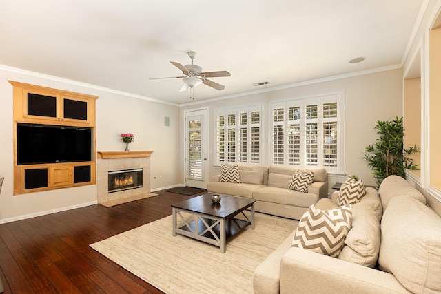 living area featuring dark wood-type flooring, a wealth of natural light, visible vents, and crown molding