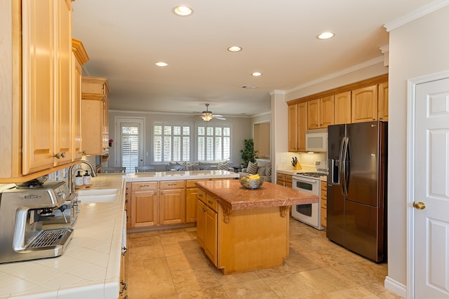 kitchen featuring tile countertops, white appliances, a peninsula, and ornamental molding