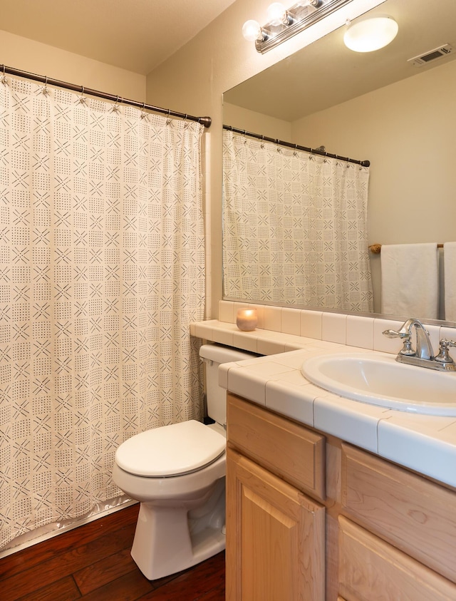 bathroom featuring visible vents, vanity, toilet, and wood finished floors