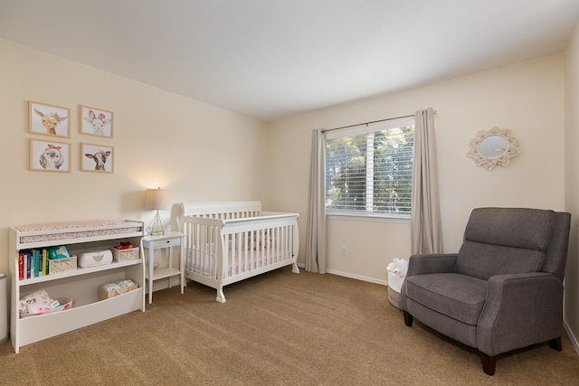 carpeted bedroom featuring a crib and baseboards