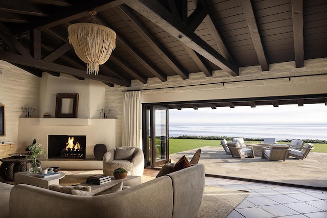 living room featuring a warm lit fireplace, high vaulted ceiling, beamed ceiling, and an inviting chandelier