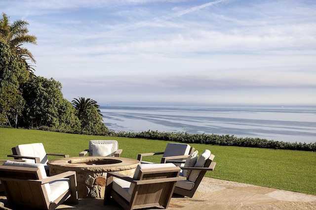 view of patio with an outdoor fire pit and a water view