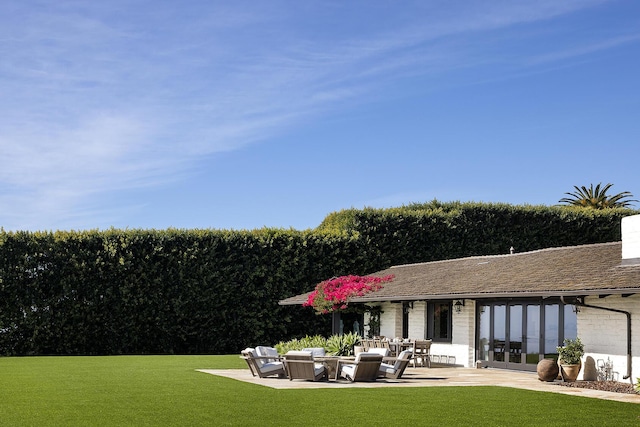 rear view of property featuring an outdoor hangout area, a yard, french doors, and a patio area