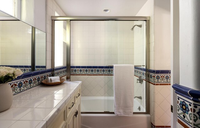 full bathroom featuring bath / shower combo with glass door and vanity