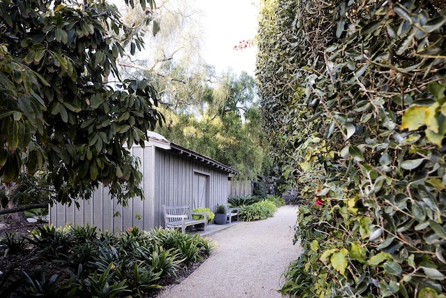 view of property exterior featuring fence and an outbuilding