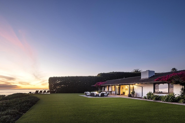 exterior space featuring an outdoor hangout area, a yard, a chimney, and a patio