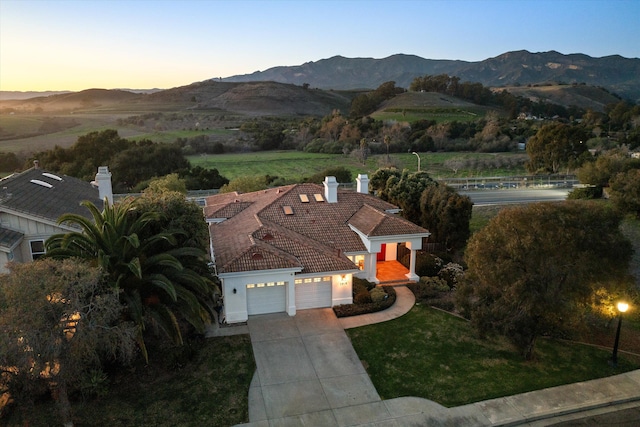 aerial view at dusk featuring a mountain view