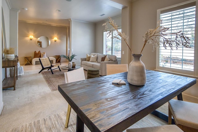 carpeted dining room featuring visible vents and crown molding