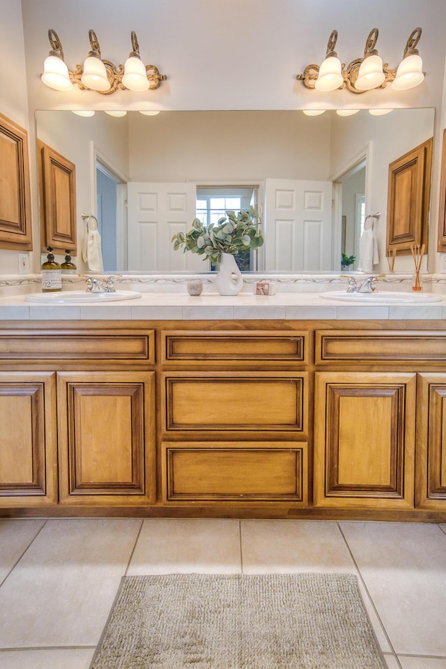 full bath with double vanity, tile patterned flooring, and a sink