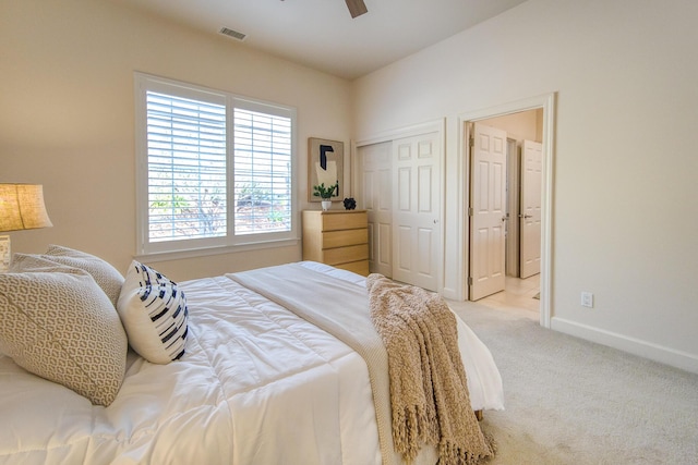 bedroom featuring a closet, light colored carpet, visible vents, a ceiling fan, and baseboards