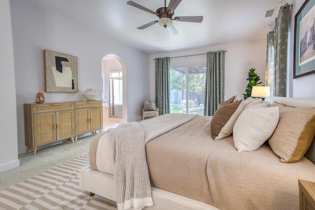 bedroom with arched walkways, visible vents, a ceiling fan, light carpet, and access to outside