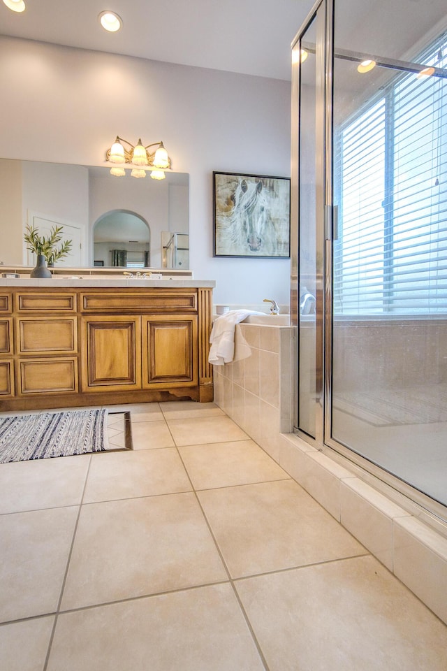 full bath with double vanity, a shower with door, a garden tub, tile patterned flooring, and recessed lighting