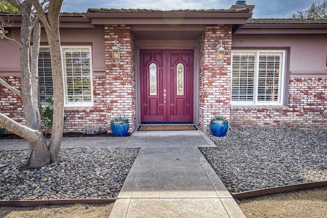 doorway to property with brick siding