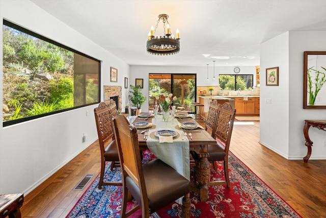 dining room with baseboards, hardwood / wood-style flooring, and visible vents