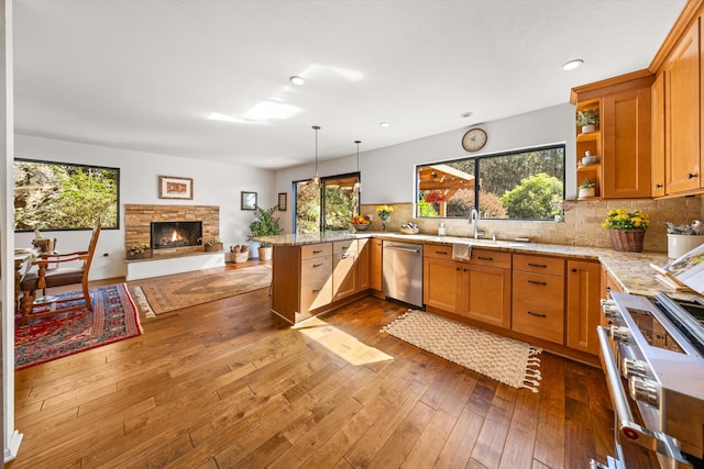 kitchen featuring a peninsula, open floor plan, appliances with stainless steel finishes, and plenty of natural light