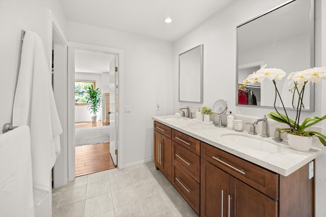 full bath with double vanity, a sink, tile patterned floors, and recessed lighting