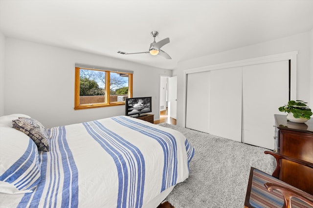 bedroom with visible vents, carpet, ceiling fan, and a closet