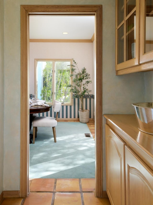 doorway with baseboards, ornamental molding, and recessed lighting