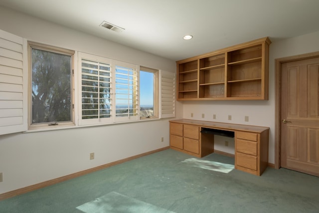 unfurnished office with baseboards, visible vents, light colored carpet, built in desk, and recessed lighting