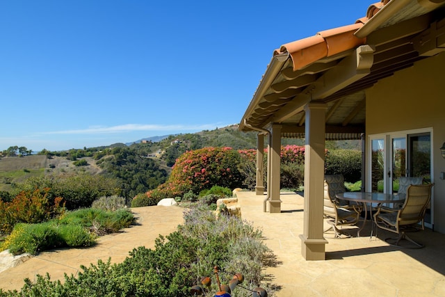 view of patio with a mountain view and outdoor dining space