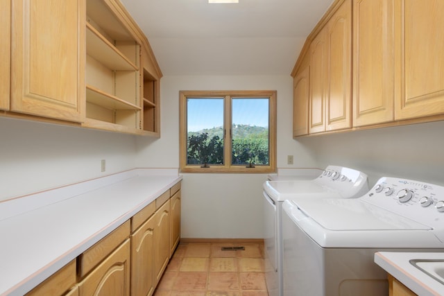 laundry room featuring washer and dryer, cabinet space, and baseboards