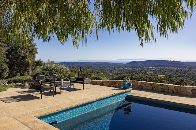 view of pool featuring a patio area and a mountain view