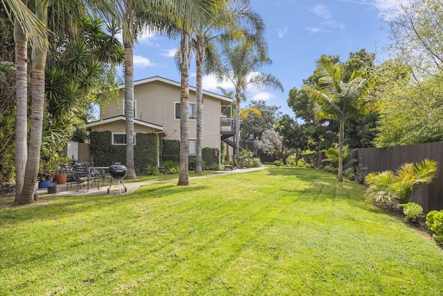 view of yard with a balcony, a patio area, and fence