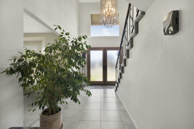 tiled entryway featuring stairs, a notable chandelier, french doors, and baseboards