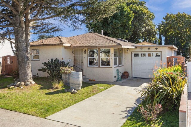 ranch-style house with a garage, driveway, a front yard, and stucco siding