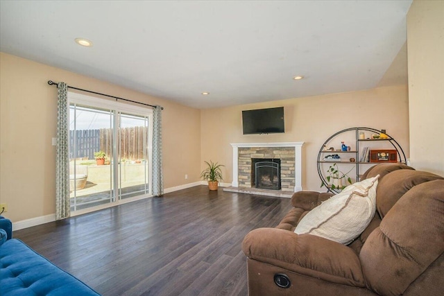 living area featuring recessed lighting, baseboards, wood finished floors, and a stone fireplace