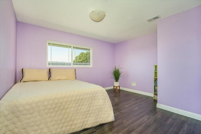 bedroom featuring dark wood-type flooring, visible vents, and baseboards