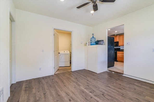 spare room featuring light wood finished floors, washer / clothes dryer, visible vents, and a ceiling fan