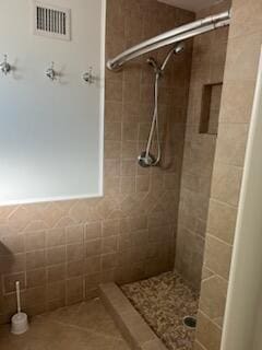 bathroom with a stall shower, tile patterned flooring, and visible vents