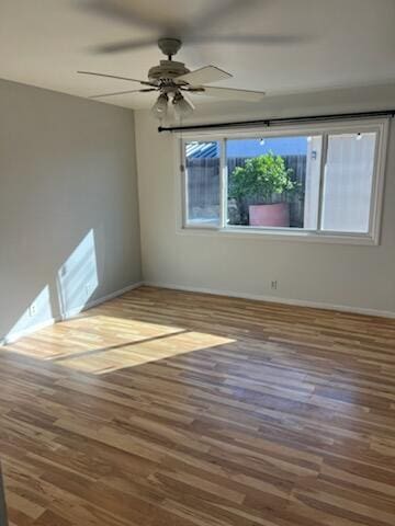 spare room featuring ceiling fan, wood finished floors, and baseboards