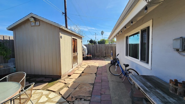 view of patio / terrace with an outdoor structure and a fenced backyard