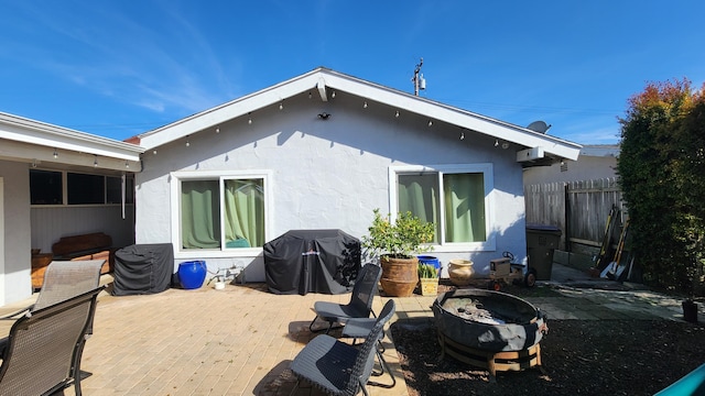 back of house with a patio area, fence, and stucco siding