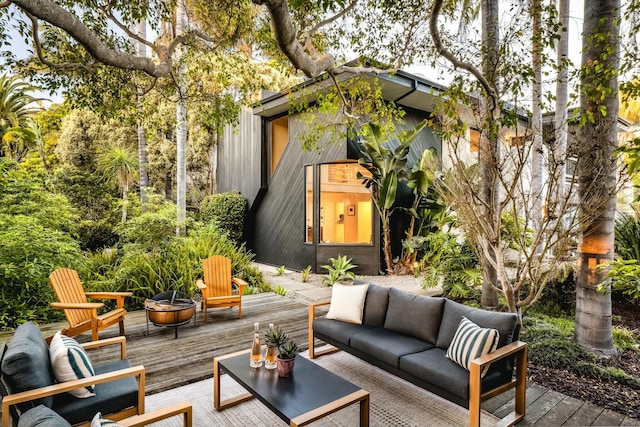 view of patio featuring a wooden deck and an outdoor living space with a fire pit