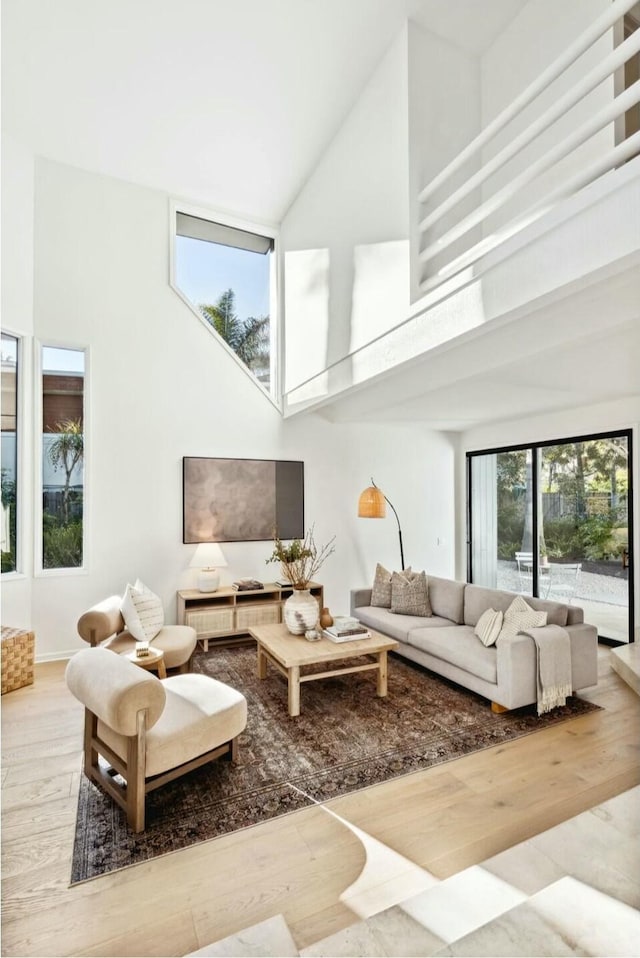 living room with a high ceiling and wood finished floors