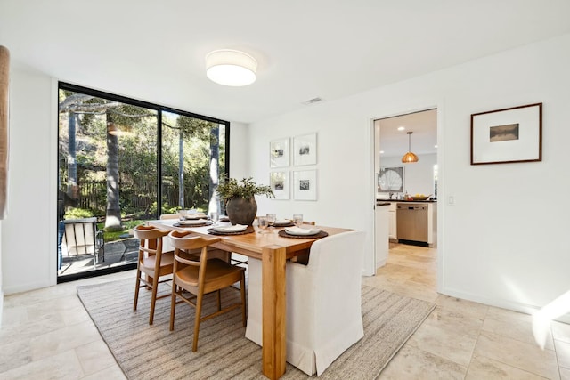 dining room featuring visible vents, a wall of windows, and baseboards